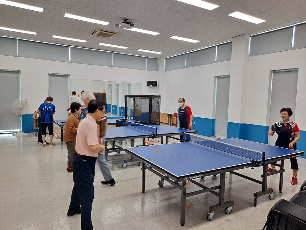교육장에서 탁구를 교육중인 강사와 배우는 교육생들 모습