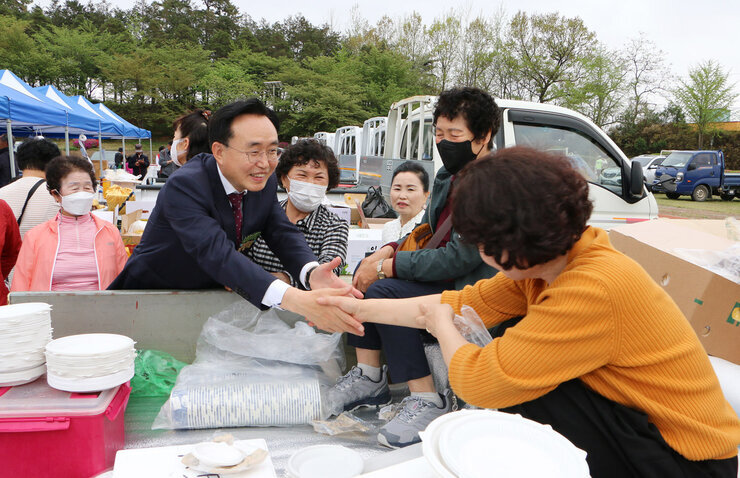 공산면민의 날 행사 나주시장이 음식을 준비하는 면민과 악수를 하는 모습
