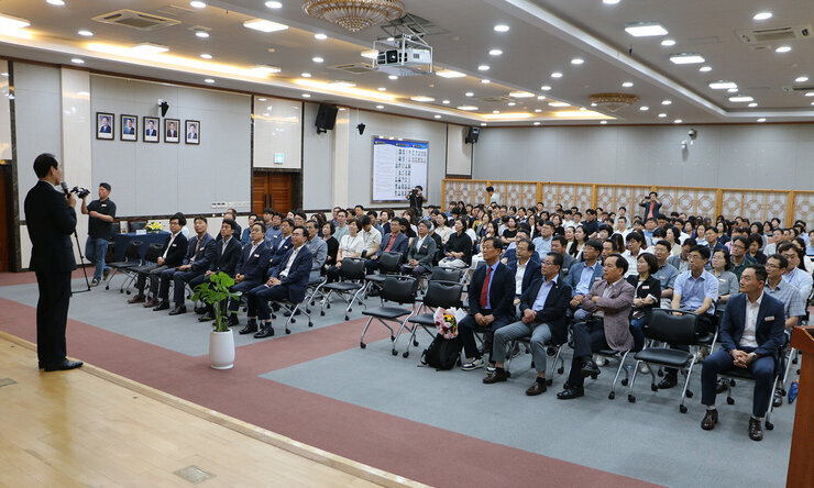 제8회 더 큰 나주아카데미 단상에서 강의를 하고 있는 강사의 옆모습과 강의에 참석한 직원들이 앉아 있는 앞모습 전면