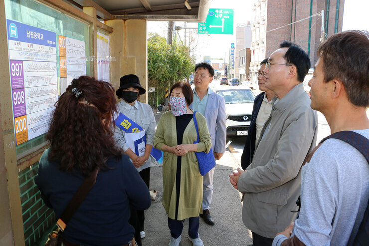 대중교통 노선개편 시행 현장 점검 나주시장이 남평중 환승 정류장에서 시민들과 부착된 노선표를 보고 있는 모습