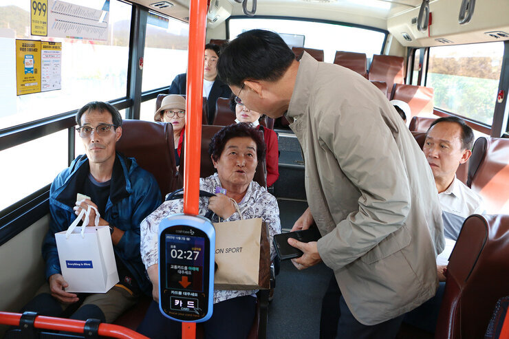 대중교통 노선개편 시행 현장 점검 나주시장이 버스에 탑승 앉아 있는 시민들에게 인사를 건네며 대화를 하고 있는 모습