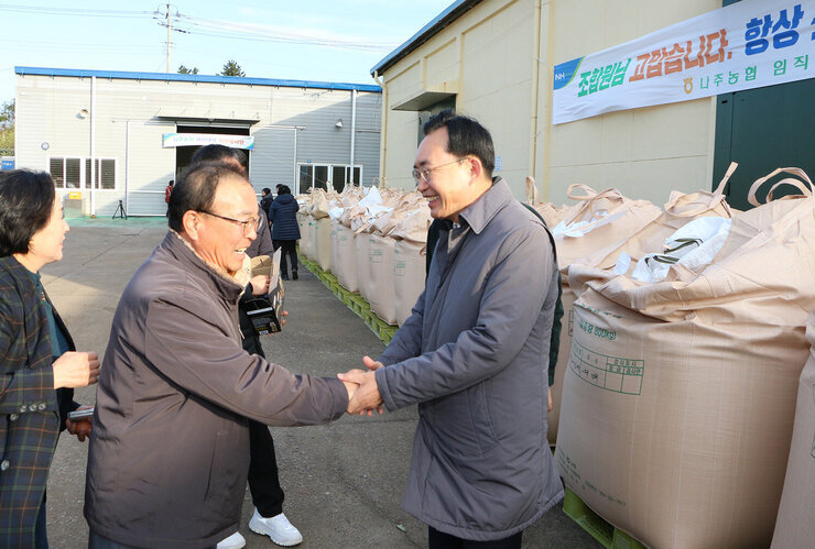 공공비축미곡 수매현장 방문 나주시장이 남성 어르신과 악수를 하며  뭇음지으며 이야기를 나누는 모습
