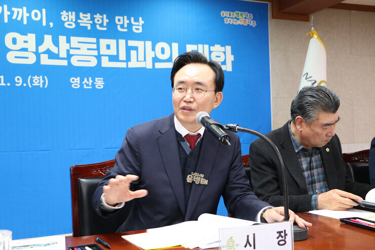 영산동 주민과의 대화 나주시장이 주민의 질문에 담당 간부공무원 쪽을 바라보며 답변의 요지를 설명하고 있는 모습 한손을 들고 말하고 있다