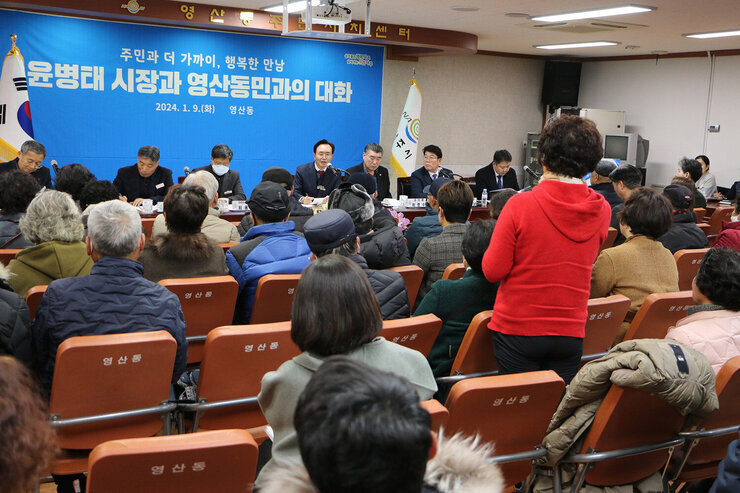 영산동 주민과의 대화 여성 주민이 서서 질문을 하고 있고 나주시장이 대화석에서 질문에 대한 답변을 주고 받고 있는 모습