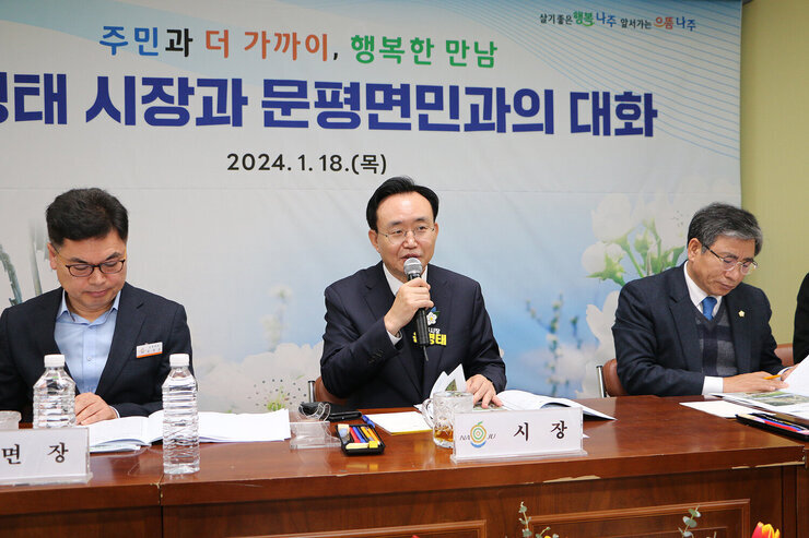 문평면 주민과의 대화 나주시장이 주민의 질의에 마이크를 잡고 답변을 하고 있는 모습 양 옆으로 면장과 시의장이 보인다