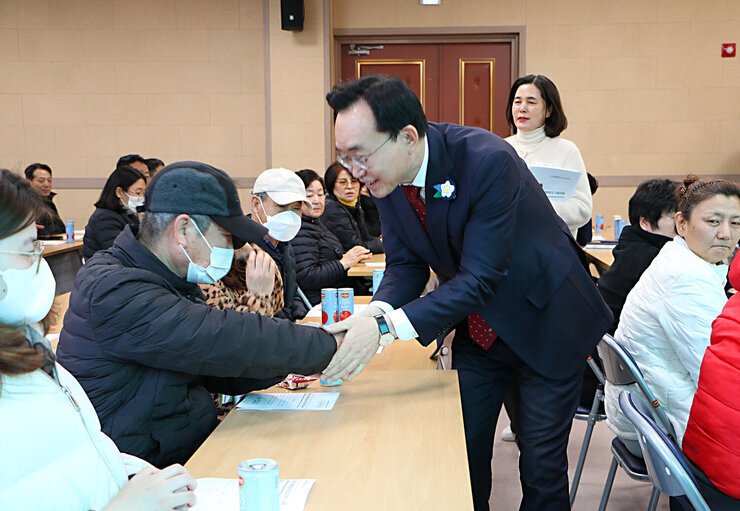 장애인 일자리 참여자 집합교육 나주시장이 교육전 교육장에 앉아 있는 남성 참여자와 악수를 하며 인사를 하고 있는 모습