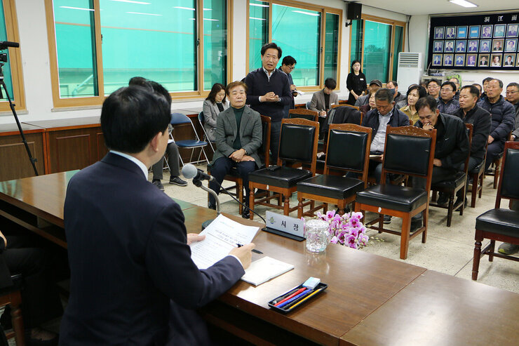 대중교통 환승불편 해소대책 발표 면민 한분이 자리에 서서 질문을 하고 있고 나주시장이 앞쪽 자리에 앉아 듣고 있는 뒷모습