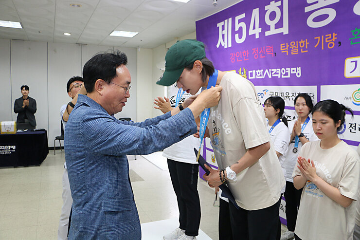 봉황기 전국 사격대회 시상식 나주시장이 여성 단체 1위팀 김예지 선수에게 트로피를 전달하고 있는 모습