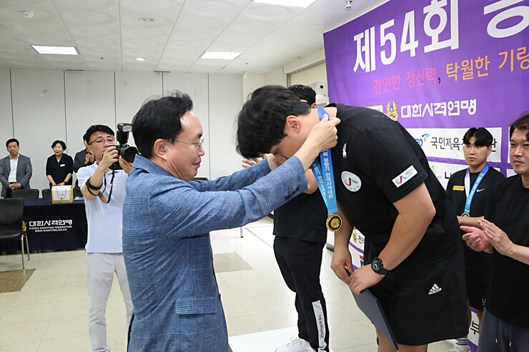 봉황기 전국 사격대회 시상식 나주시장이 남성 단체 1위팀 선수에게 메달을 목에 걸어주고 있는 모습