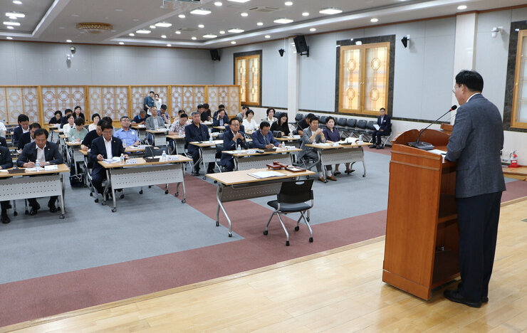 민주평화통일자문회의 정기회의 단상에서 인사말을 하고 있는 나주시장의 뒷편 측면에서 촬영한 모습 참석자들의 앉아 있는 앞모습도 보인다