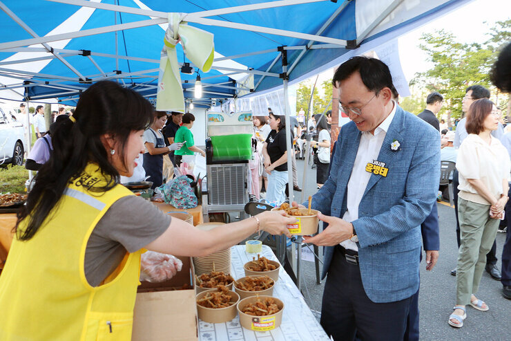나주 빛가람 하이볼 페스티벌 나주시장이 행사장에 마련된 부스에서 오리날개 튀김을 판매자에게 선물로 받고 있는 모습