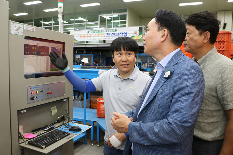 추석 명절 배 선과장 방문 나주시장이 켄베이어 의 당도 측정 기계 앞에서 관계자에게 설명을 듣고 있는 모습