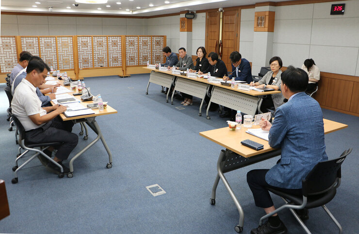 시민 직소상담실 민원 추진상황 보고회 회의를 주재하는 나주시장의 뒷편 좌측면에서 촬영한 보고회 모습 간부들이 앉아 있는 모습도 보인다