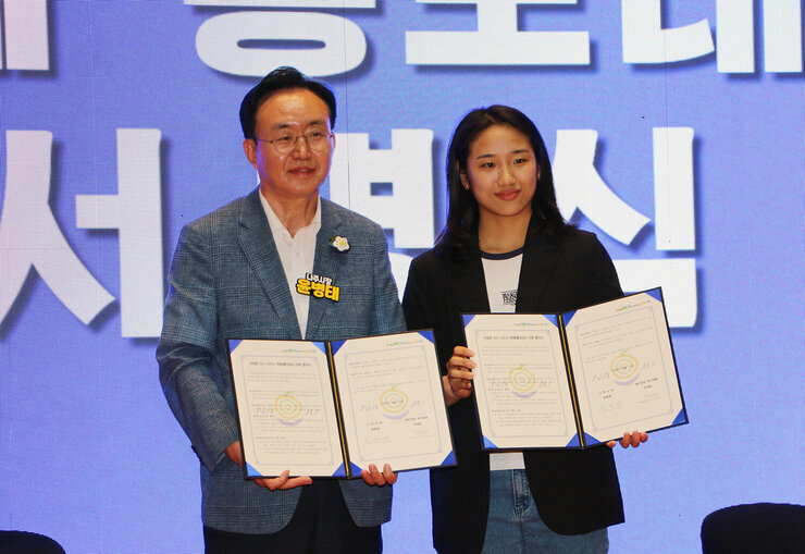 파리올림픽 금메달리스트 안세영 선수 나주 환영행사 나주시장과 안세영 선수가 나주시 명예홍보대사 서명식을 마치고 기념촬영을 하고 있는 모습