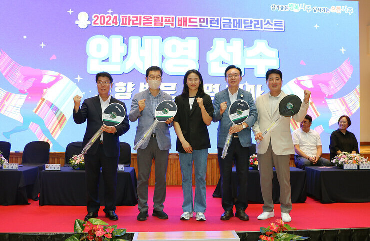 파리올림픽 금메달리스트 안세영 선수 나주 환영행사 안세영 선수와 나주시장, 국회의원, 체육회장, 나주시의회 의장이 싸인 라켓을 들고  함께 기념촬영을 하고 있는 모습