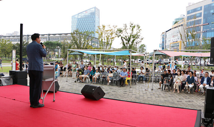 추석맞이 다문화가족 노래자랑 인사말을 하고 있는 나주시장의 뒷편에 촬영한 사진 참석자들의 앞모습이 함께 보인다