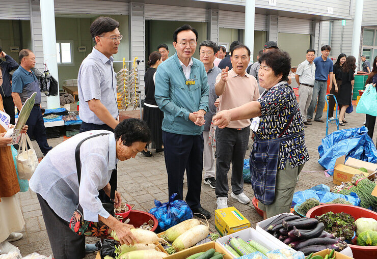 추석 명절맞이 공산5일시장 장보기 행사 나주시장이 야채를 판매하는 여성 상인분의 이야기를 듣고 있는 모습