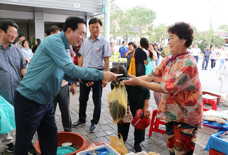 추석 명절맞이 공산5일시장 장보기 행사 나주시장이 새우를 판매하는 여성 상인분에게 새우를 구매하고 나주사랑상품권을 건네고 있는 모습