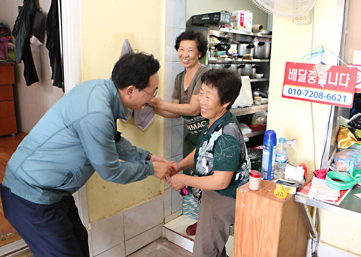 공산면 상가 방문 나주시장이 통닭집의 여성 사장님과 악수를 나누며 인사를 하는 모습