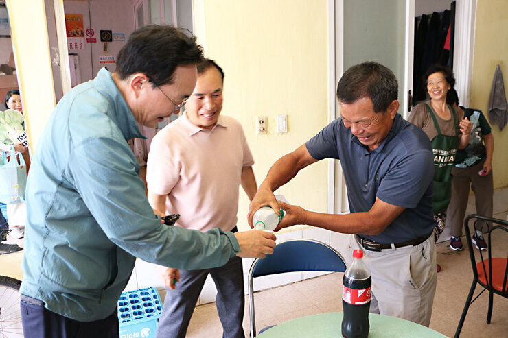 공산면 상가 방문 나주시장이 통닭집의 남성 사장님께 시원한 음료를 종이컵에 받고 있는 모습