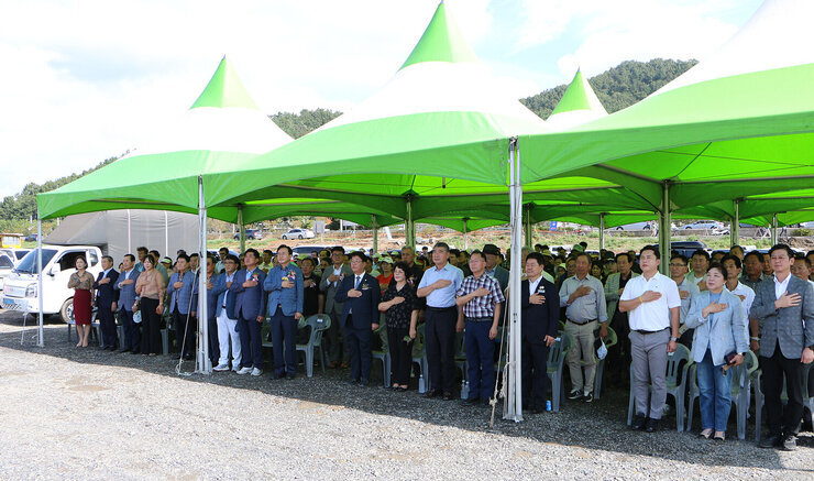 안창 파크골프장 조성공사 착공식 나주시장과 나주시의회 의장, 도의원, 파크골프협회장 및 참석자들이 자리에서 일어나 국기에 대한 경례를 하고 있는 모습