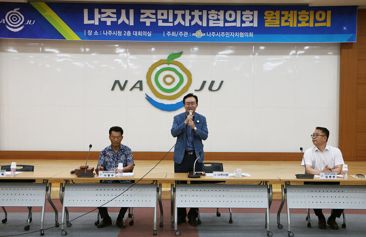 나주시 주민자치협의회 월례회의 나주시장이 대회의실에 말녀된 월례회의 자리에서 일어나 마이크를 잡고 인사말을 하고 있는 모습 