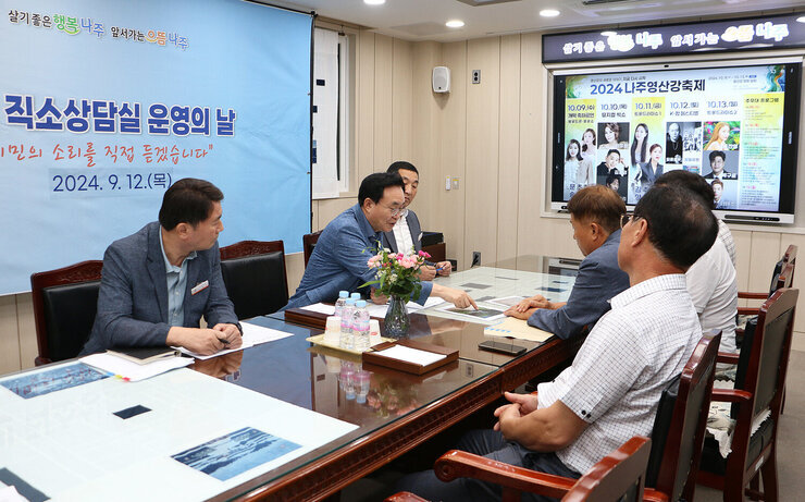 시민 직소상담실 운영의 날 나주시장이 민원인이 준비한 자료를 함께 손으로 가리키며 설명을 듣고 있는 모습