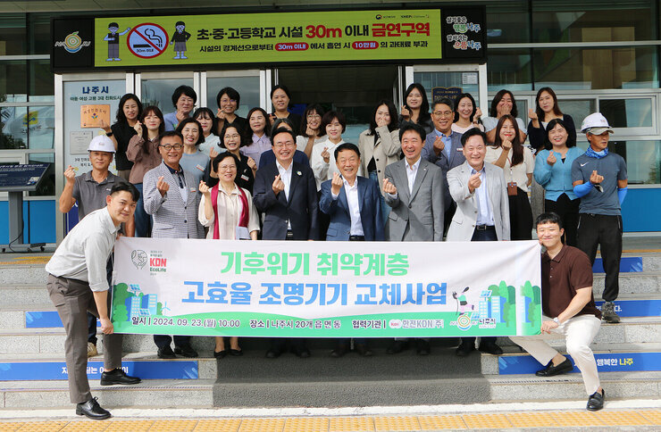 한전 KDN 취약계층 고효율 조명기기 교체 후원  나주시장과 한전KDN사장 및 시청 직원, 한전KDN 직원들이 플래카드를 펼치고 손하트를 하며 기념촬영을 하고 있는 모습