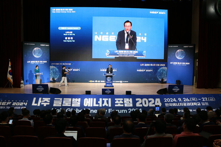 나주 글로벌 에너지 포럼 2024 개막식 무대 위 나주시장의 개회사 모습과 참석자들이 앉아 있는 모습 정면