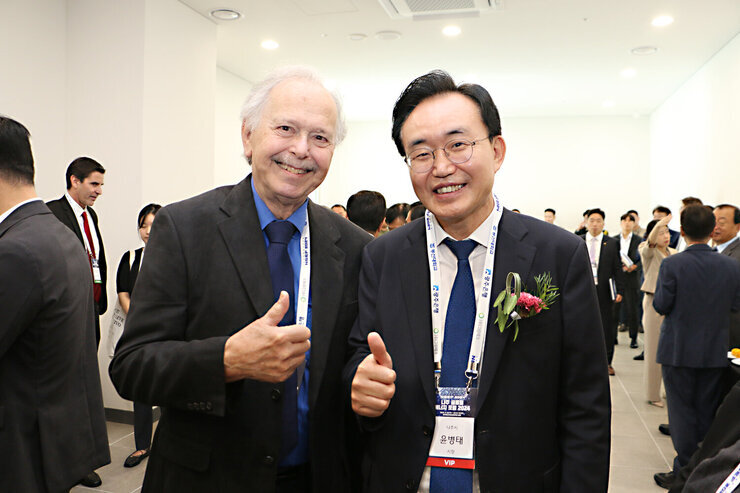 나주 글로벌 에너지 포럼 2024 개막식 나주시장과 기조 연설자인 리처드 물러 교수가 엄지손가락을 치켜 세우고 기념촬영을 하고 있는 모습