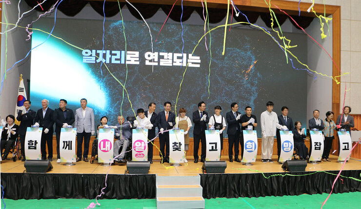 2024 전라남도 장애인 일자리 박람회 기념 세레모니 터치 버튼을 누른  후 축포가 터진 모습 단상 위의 내빈들의 모습이 보인다