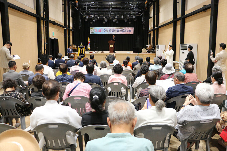 전국 시조창 나주 경연대회 나주시장의 환영사 모습과 참석자들의 앉아 있는 뒷모습 정면