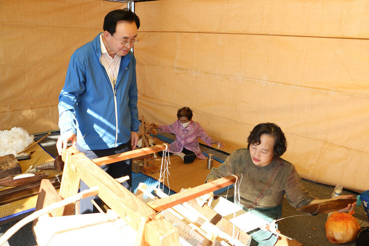 천년 나주목읍성문화 축제나주 샛골나이  체험 부스에서 여성 관계자와 씰을 만드는 과정을 체험하고 있는 모습 여성 관계자가 기구 앞에 앉아 있고 나주시장이 바라보고 있다