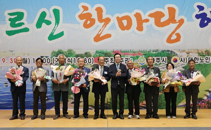 제28회 노인의 날 어르신 한마당 개막식 나주시장이 시상자 9명과 무대위에서 기념촬영을 하고 있는 모습 나주시장은 박수를 쳐주고 있다