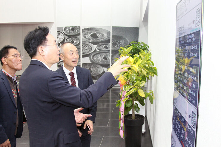 국립나주박물관 특별전시 개막행사 나주시장이 국립나주박물관장에게 벽에 표시된 전시실  운영표에 대해 설명을 듣고 있는 모습