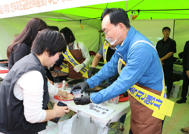 영산강축제 한우(한돈)고기 소비 촉진행사 나주시장이 구운 소고기를 담은 용기를 관광객에게 나눠 드리고 있는 모습