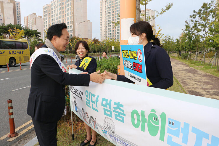 초등학교 등굣길 교통안전 캠페인 나주시장이 녹색어머니연합회 회원과 악수를 나누고 있는 모습