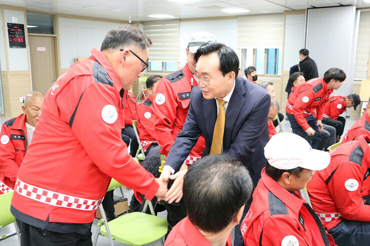 나주시 산불진화대 격려 나주시장과 산불진화대원 남성분이 손을 잡으며 인사를 나누고 있는 모습