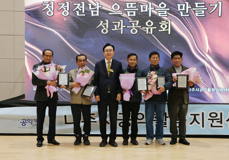 청정전남 으뜸마을 만들기 성과 공유회 시상이 끝나고 각 마을 대표 4명과 나주시장이 기념촬영을 하고 있는 모습