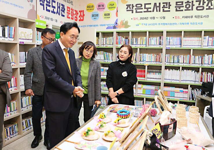 LH5단지 프로그램 성과나눔 전시회 나주시장이 테이블에 전시된 작품들을 바라보고 있는 모습
