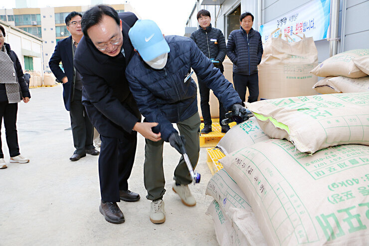 다시면 수매현장 방문 나주시장이 품질관리원과 쌀포대에 도장 표기를 하고 잇는 모습