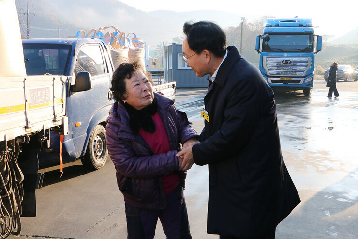 다도면 DSC 수매현장 방문 나주시장이 현장을 방문하여 여성 농민분과 두손을 맞잡으며 대화를 나누는 모습