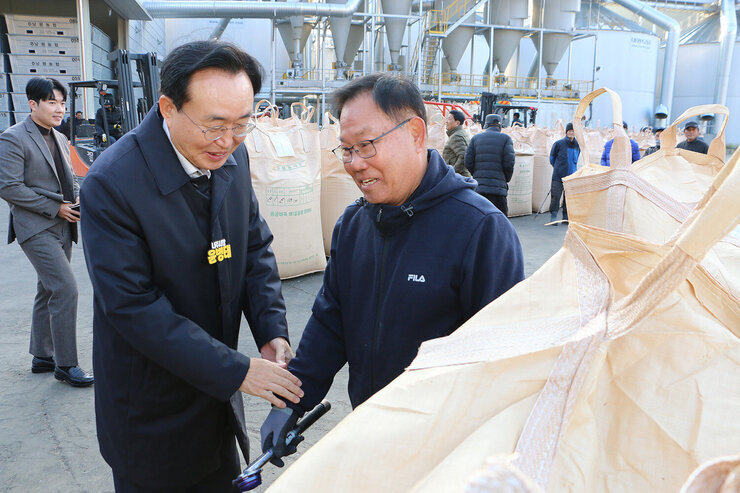 다도면 DSC 수매현장 방문 나주시장이 톤백 앞에서 남성 품질 관리원의 한 손을 잡고 인사를 나누는 모습