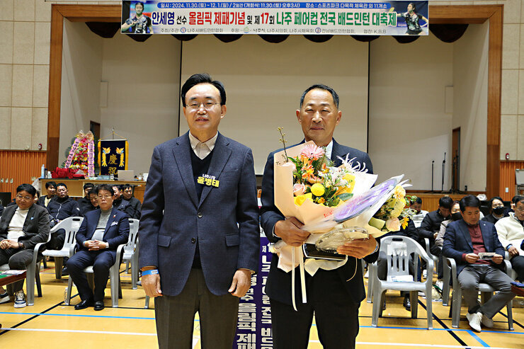 제17회 나주 페어컵 배드민턴 대축제 개회식 나주시장이 시상을 받은 남성과 함께 기념촬영을 하고 있는 모습