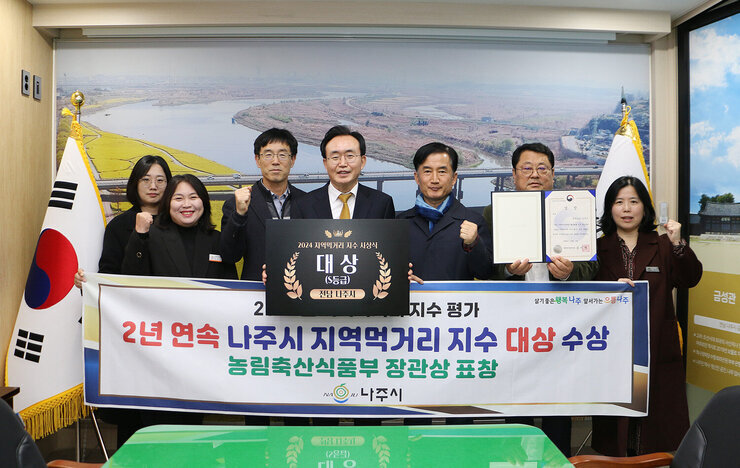 나주시 지역먹거리 지수 대상 수상 나주시장과 담당부서 직원들이 플래카드를 펼치고 기념촬영을 하고 있는 모습