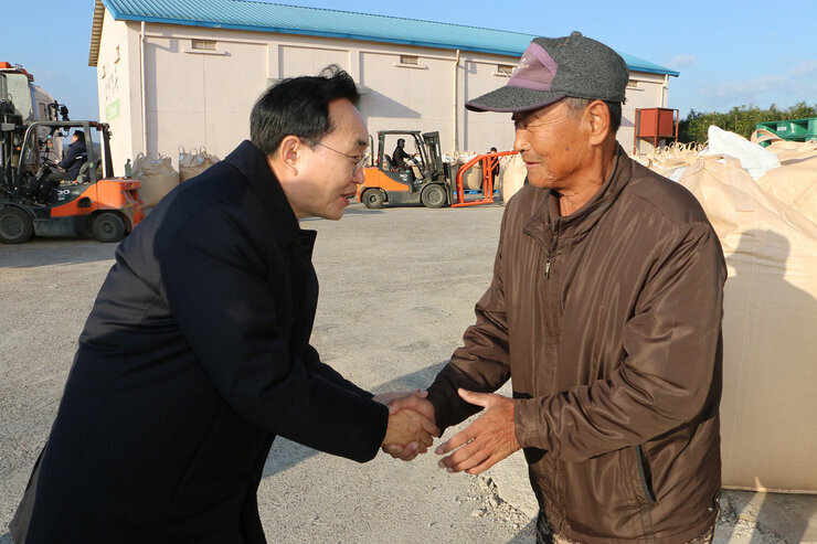 영산포 이창창고, 공산면 창고 수매현장 나주시장이 동촌창고에서 남성 농민과 악수를 나누는 모습