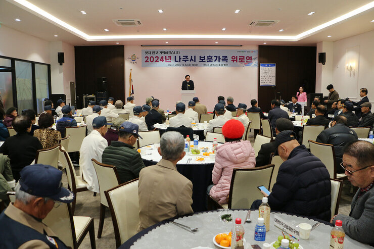 보훈가족 위로연 나주시장의 축사모습과 참석자들이 운형테이블에 앉아 있는 모습