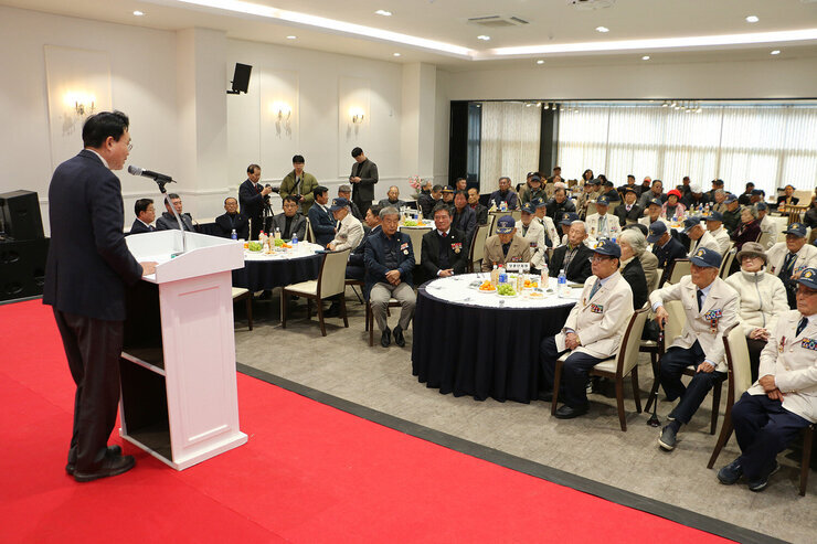 보훈가족 위로연 나주시장의 축사모습 좌측 편에서 촬영한 모습 참석자들의 앉아 있는 앞모습이 보인다