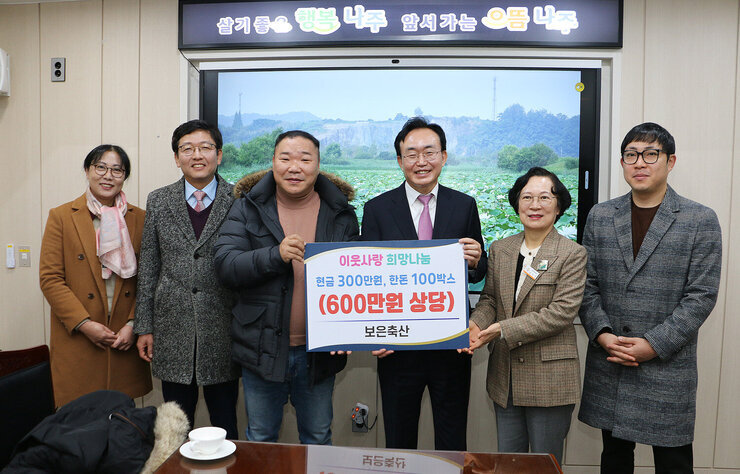 보은축산 후원금 및 물품 기탁식 나주시장과 보은축산 대표 및 관계자들이 판넬을 들고 기념촬영을 하고 있는 모습