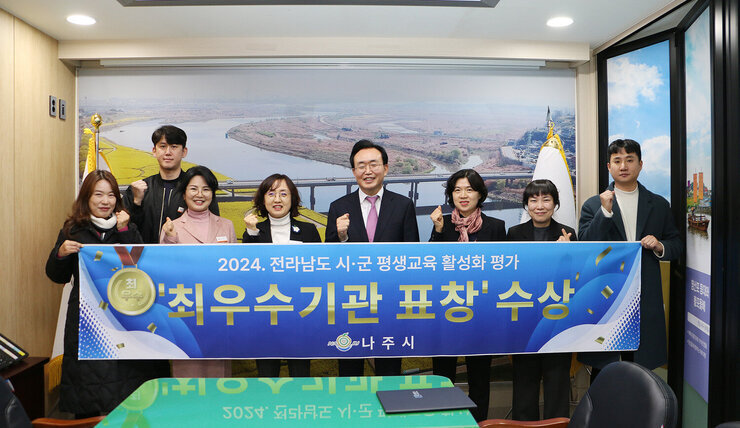 전라남도 시군 평생교육 활성화 평가 최우수기관 표창 나주시장과 담당부서 직원들이 플래카드를 펼치고 기념촬영 하는 모습